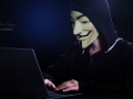 An indifinited person with Anonymous mask and notebook